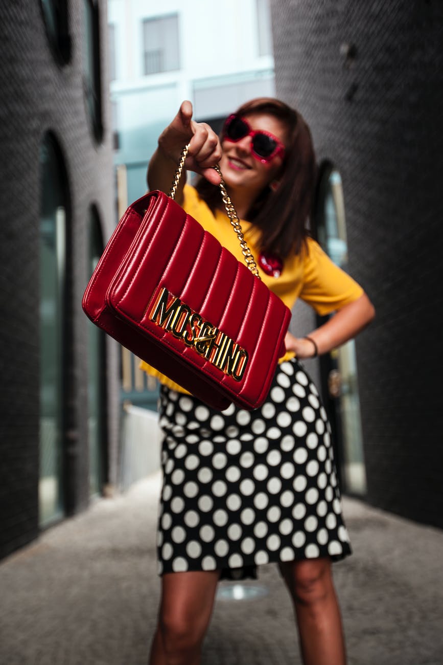 woman wearing yellow crew neck t shirt while holding red handbag